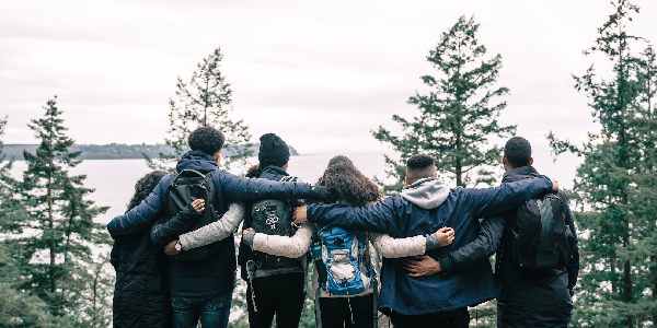 A group of friends overlooking a lake and forest view