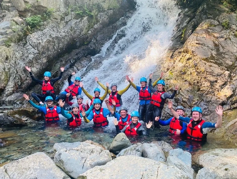 Group of participants waving from a waterfall