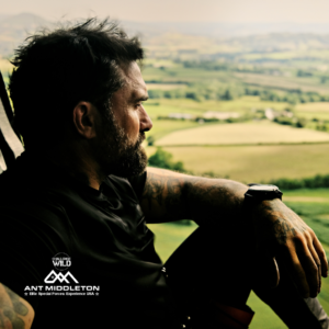 Elite Special Forces Leadership, Ant Middleton, in a chopper overlooking a lush green landscape.